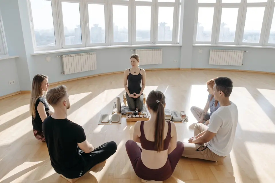 A group meditating in a sunlit studio